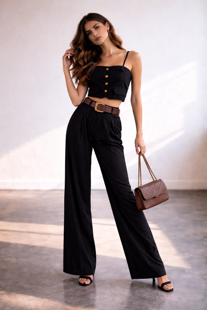 Chic black high-waisted wide leg trouser set with fitted crop camisole top, styled with minimal sandals and a leather shoulder bag, perfect for modern elegant women’s fashion and summer evening wear.
