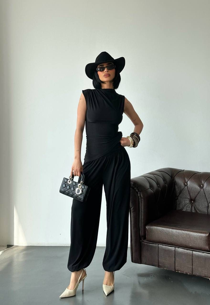 Modern black draped top and wide-leg pants set from Cleo’s Shop styled with sunglasses and handbag.